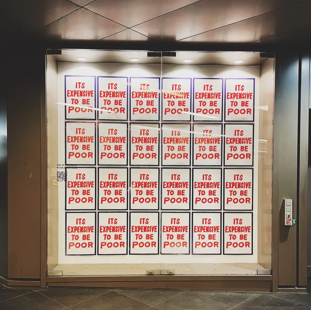 a grid of red posters reading it's expensive to be poor
