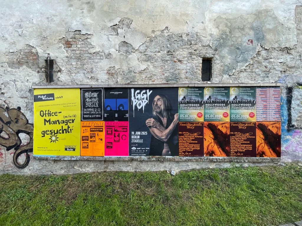 a weathered Berlin wall pasted with gig posters