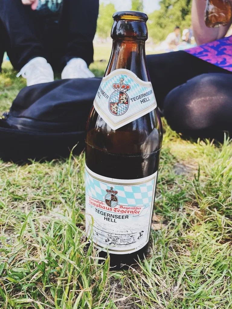 a bottle of Tegernseer Hell on park grass