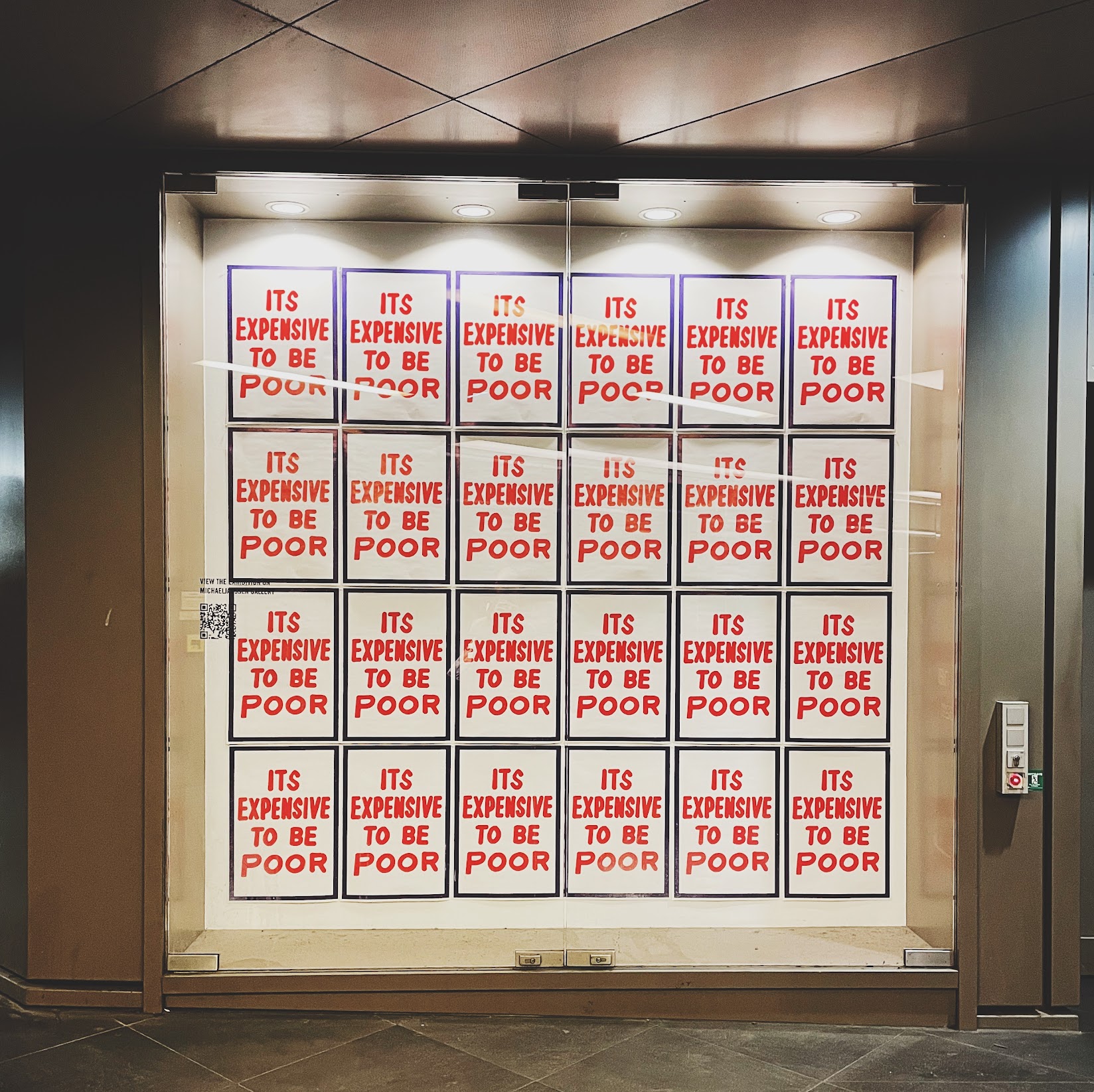 a grid of red posters reading it's expensive to be poor