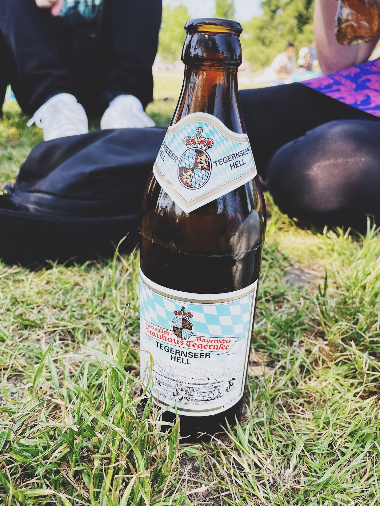 a bottle of Tegernseer Hell on park grass