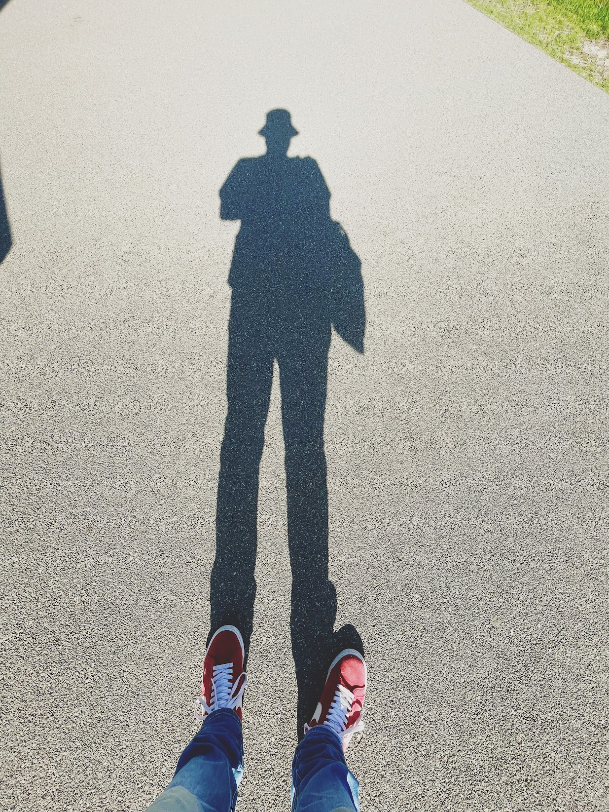 the photographer's long shadow with a hat and red shoes
