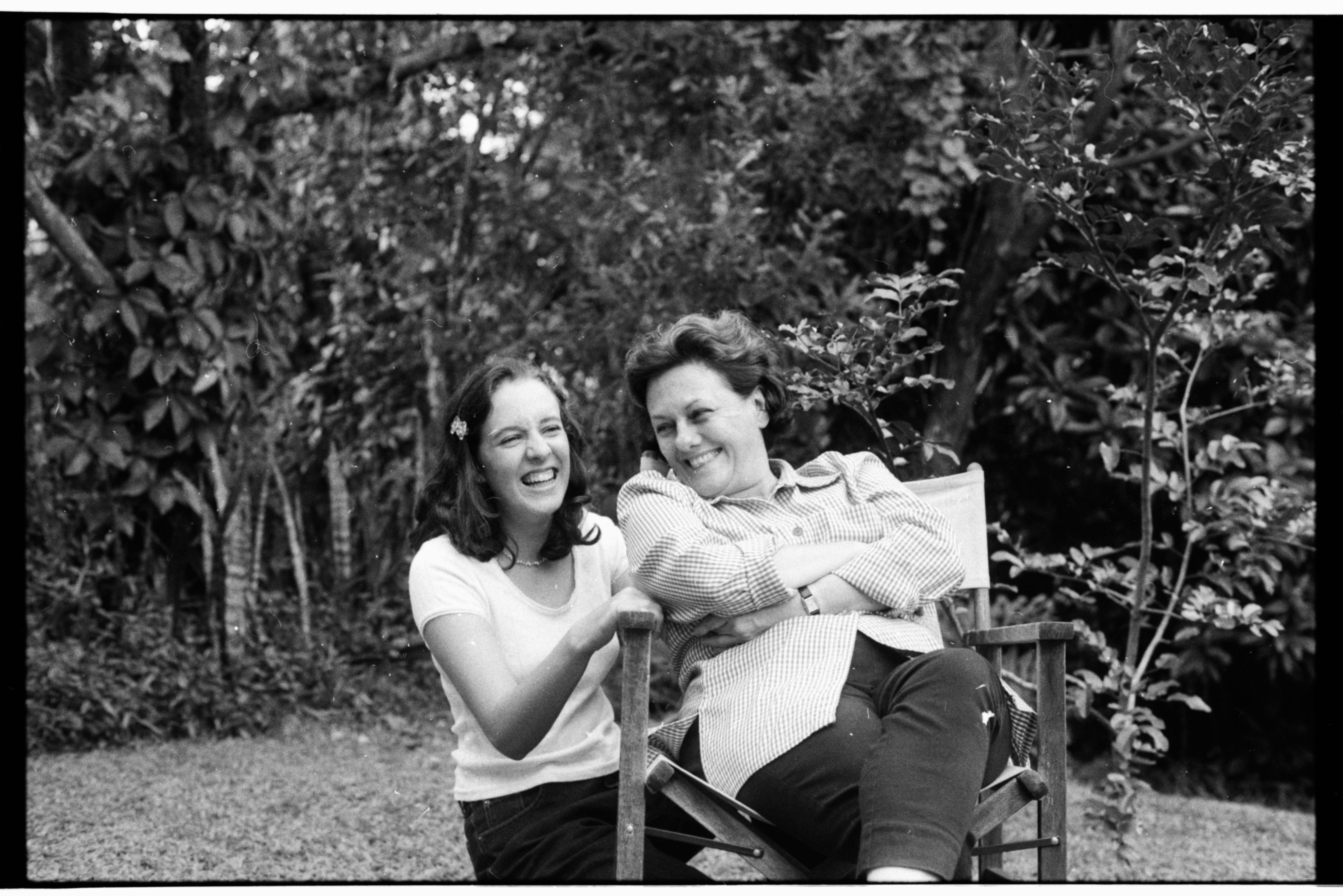 two people laughing in a garden, black and white film
